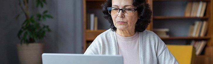 Frau sitzt am Laptop