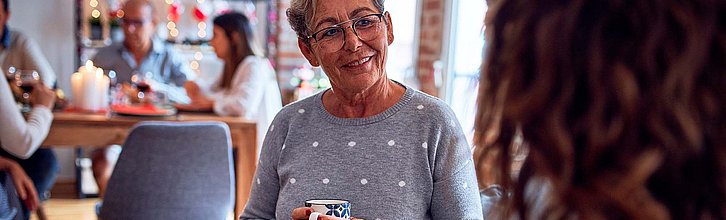 Frau mit Kaffeetasse in der Hand im Gespräch