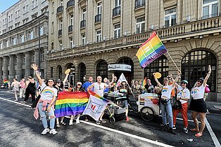 Menschen mit Regenbogenflaggen posieren